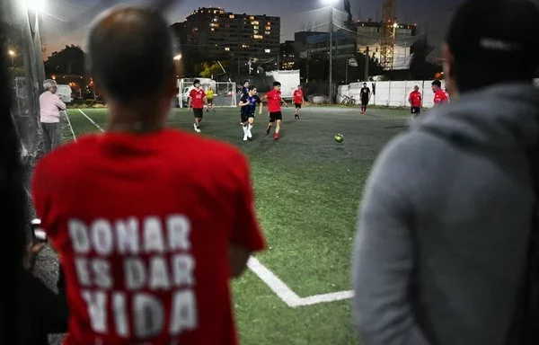 A man wearing a T-shirt titled 'Donate Is Life' watches a Chilean transplant-recipient football team training session in Santiago. [Rodrigo Arangua/AFP]