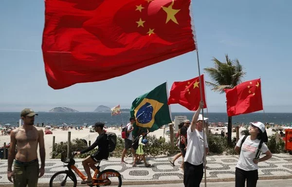 Los chinos esperan a que la caravana del presidente chino Xi Jinping pase por la playa de Ipanema durante la cumbre del G20 en Río de Janeiro, Brasil, en noviembre. [Ludovic Marín/AFP]