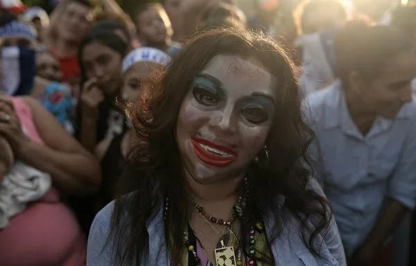 A protester wears a mask depicting Nicaraguan Vice-President Rosario Murillo during the 'March of Mocking' against her and Nicaraguan President Daniel Ortega in Leon, Nicargua, in July 2018. [Marvin Recinos/AFP]