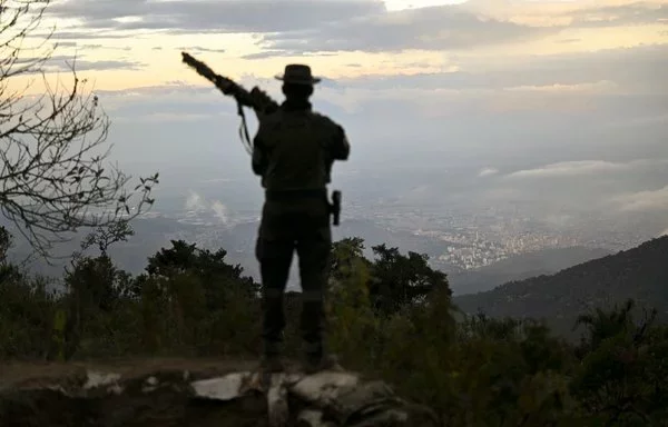 
Un oficial de policía custodia la base Alto del Huey en el Parque Natural Farallones, cerca de Cali, Colombia. Durante más de medio siglo, grupos armados clandestinos han explotado la minería ilegal de oro en estas montañas envueltas en niebla, utilizando mercurio, un metal tóxico que contamina el suministro de agua para los 2,2 millones de residentes de Cali. [Joaquín Sarmiento/AFP]        