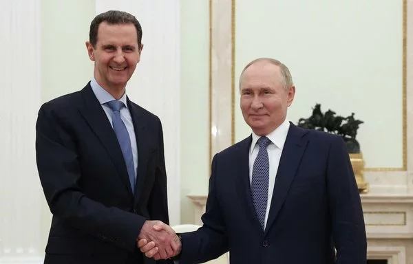 El presidente ruso Vladimir Putin (derecha) le da la mano a su homólogo sirio Bashar al-Ássad en Moscú el 24 de julio, en esta fotografía de archivo distribuida por la agencia estatal rusa Sputnik. Los rebeldes tomaron Damasco el 8 de diciembre, lo que hizo huir a al-Ássad, muy probablemente a Moscú. [Valéry Sharifulin/Pool/AFP]