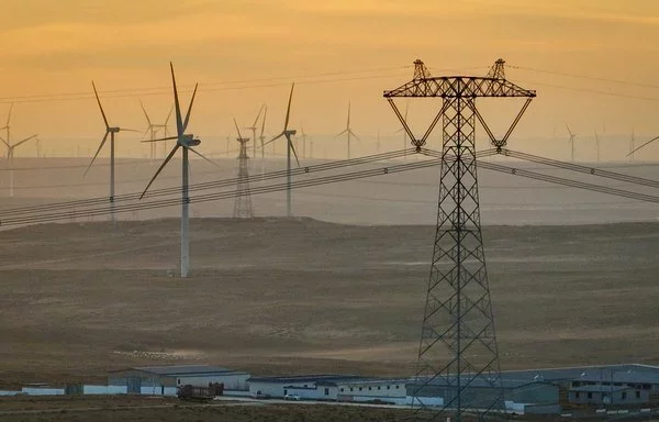 
Líneas de transmisión de energía y turbinas eólicas vistas en el desierto de Gobi en Lingwu, China, en diciembre. [AFP]        