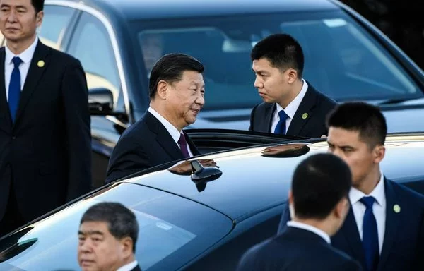 El presidente chino, Xi Jinping (centro izquierda), rodeado de agentes de seguridad, se prepara para subir a un automóvil poco después de llegar al aeropuerto internacional de Macao, en diciembre de 2019. [Anthony Wallace/AFP]