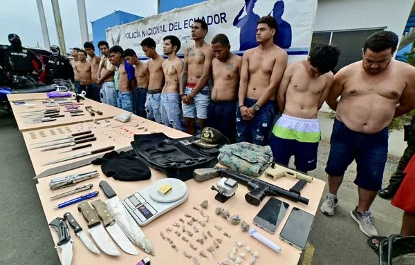 Presuntos miembros de la banda Latin King son presentados ante los medios de comunicación luego de una operación conjunta de las fuerzas armadas y la policía nacional en Durán, Ecuador, en diciembre. [Marcos Pin/AFP]