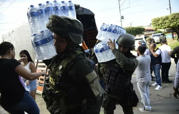 Police officers unload humanitarian aid for people displaced by recent clashes between armed groups in Tibu, Colombia. [Schneyder Mendoza/AFP]