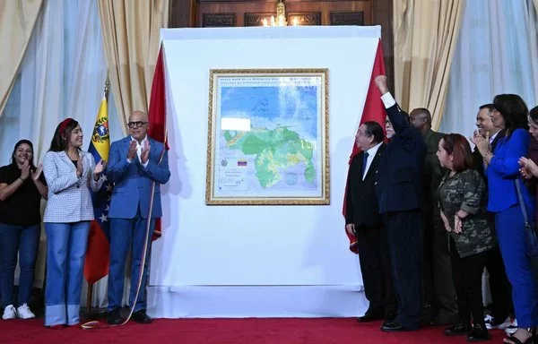 El presidente de la Asamblea Nacional de Venezuela, Jorge Rodríguez (centro-izq.) y el asambleísta Hermann Escarrá (centro-derecha), junto con otros legisladores prorégimen, revelan un nuevo mapa de Venezuela que presenta la incorporación de la región del Esequibo de Guyana en la Asamblea Nacional en Caracas en diciembre de 2023. [Federico Parra/AFP]