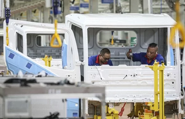 
Empleados trabajando en una cadena de ensamblaje de vehículos de nuevas energías en una fábrica de BYD en Huai'an (China).  [AFP]        