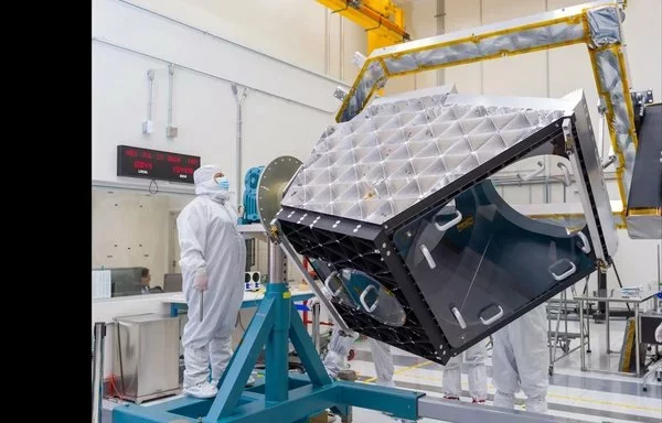 Un técnico opera un equipo articulado para rotar el banco óptico de aluminio del buscador de objetos cercanos a la Tierra NEO Surveyor, parte del telescopio de la nave espacial, en una sala limpia del Laboratorio de Propulsión a Chorro de la NASA en el sur de California el pasado 17 de julio. La nueva nave espacial de caza de asteroides de la NASA buscará los asteroides y cometas más difíciles de encontrar que puedan representar un peligro para la Tierra. Es el primer telescopio espacial de la NASA diseñado específicamente para la defensa planetaria. [NASA/JPL-Caltech]