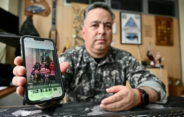 El coronel Roberto Santamaría, jefe de la policía de Durán (Ecuador), muestra en su teléfono una foto de un altar de la Santa Muerte, venerada por las bandas locales como amuleto protector. [Marcos Pin/AFP]