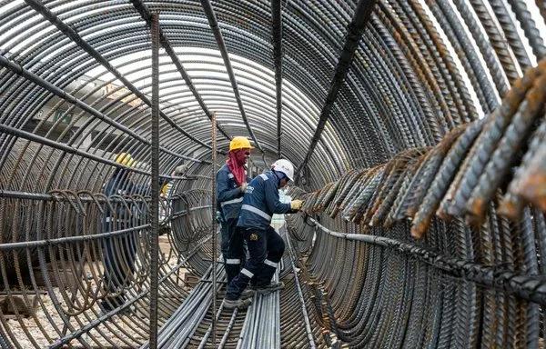 Tres trabajadores se muestran durante la instalación de pilotes para la construcción de la primera línea del metro de Bogotá. [Metro de Bogotá]