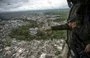 
Colombian anti-narcotics police distribute pamphlets from a helicopter over Apartadó, Antioquia, offering rewards for information leading to the capture of Gulf Clan cartel members. [Raul Arboleda/AFP]        