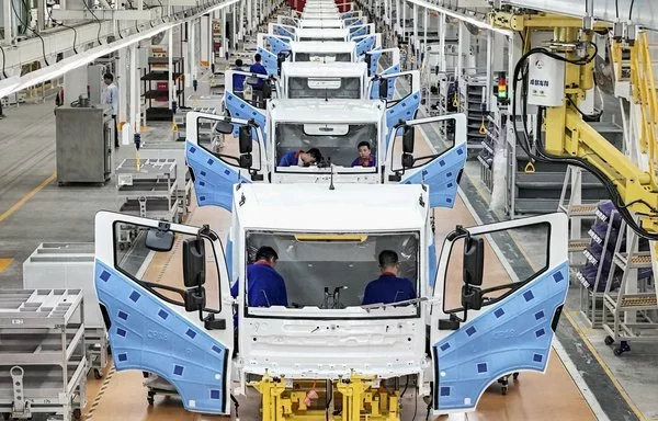 Employees work on a new energy vehicle (NEV) assembly line at a BYD factory in Huai'an, China. [AFP]