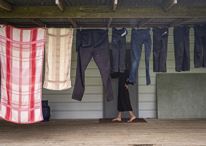 A Mennonite woman walks past hanging laundry at her home in the community of Masisea, Ucayali department, Peru. [Ernesto Benavides/AFP]