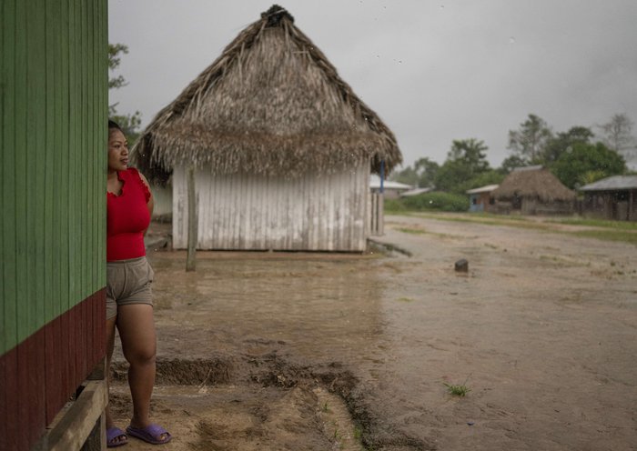 A woman looks at the rain in the Shipibo Konibo community of Caimito, Ucayali department, Peru. [Ernesto Benavides/AFP]